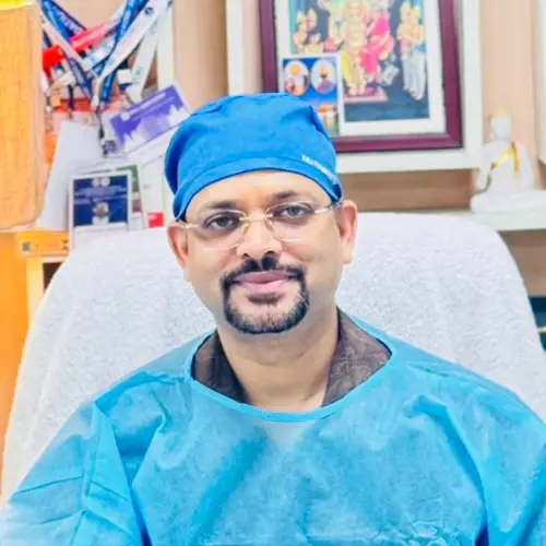 Dr. Maj Chander Parkash, TMJ specialist, portrait with blue surgical cap in clinic
